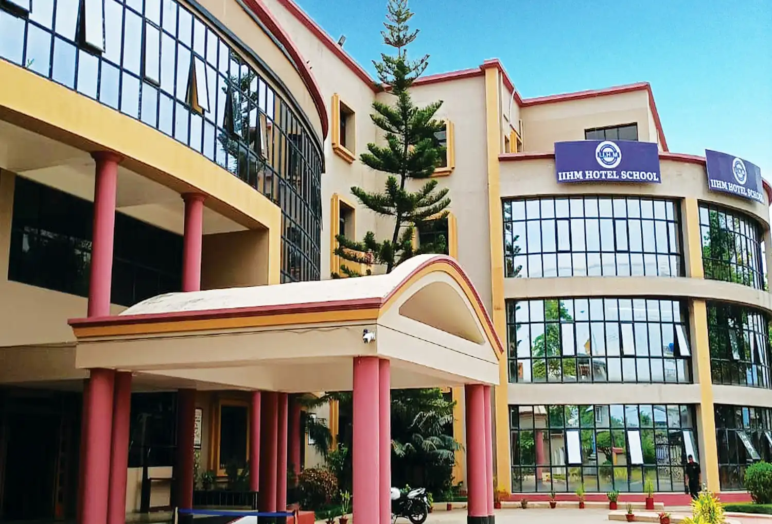 Front view of IIHM Siliguri campus with modern glass architecture, a top hotel management institute in North East India.