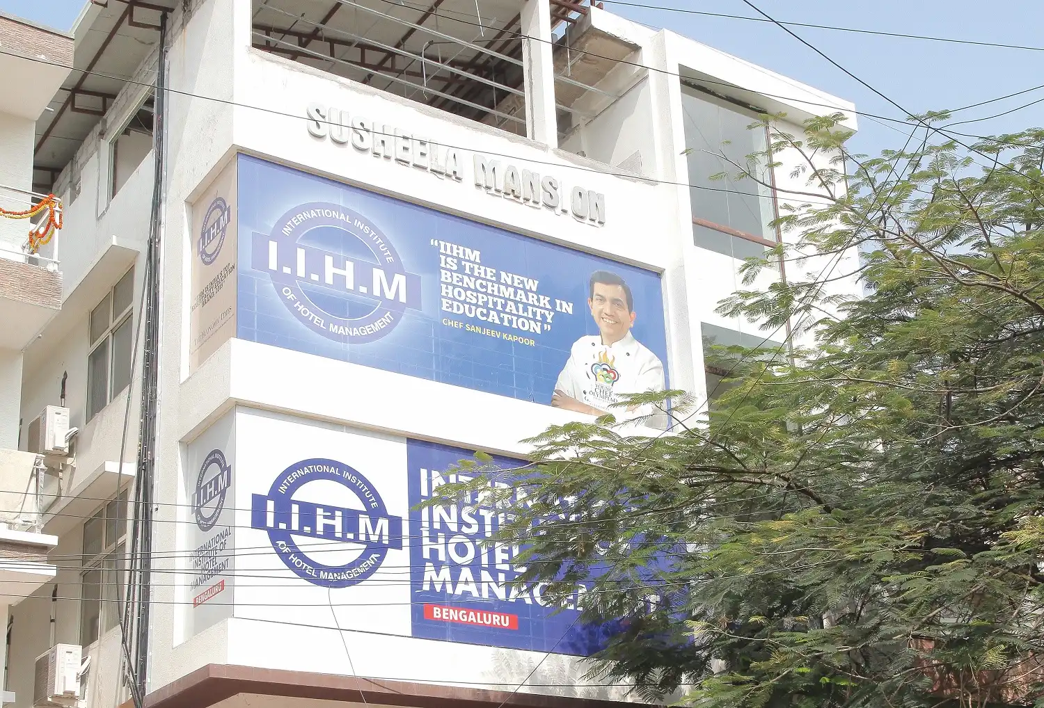 Front view of IIHM Bangalore campus featuring Chef Sanjeev Kapoor, a top hotel management college for global hospitality careers.