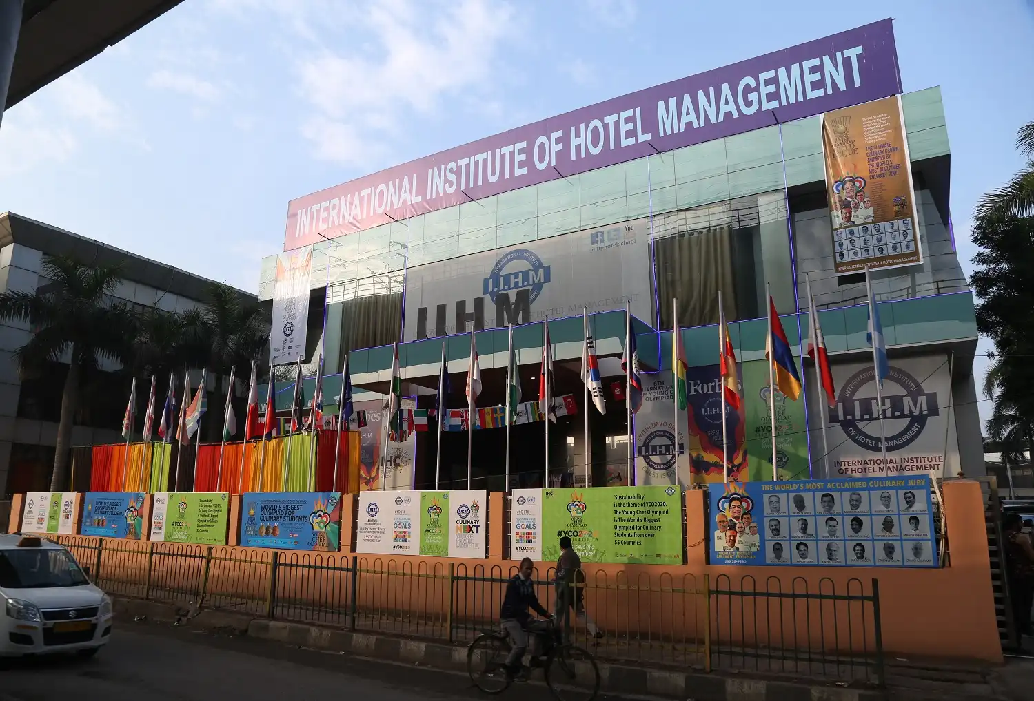 IIHM Delhi campus exterior with global flags, showcasing a top hotel management institute focused on international hospitality.